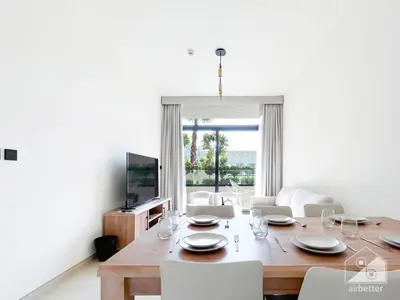 a dining room with a table with chairs and a television at Deluxe 2-Bedroom Apartment - JVC Binghatti Emerald in Dubai