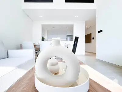 a white living room with a white couch and a table at Deluxe 2-Bedroom Apartment - JVC Binghatti Emerald in Dubai