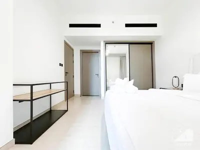 a white bedroom with two beds and a table at Deluxe 2-Bedroom Apartment - JVC Binghatti Emerald in Dubai