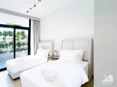 two white beds in a room with a window at Elegant 2 Bedroom Apartment -Binghatti Emerald JVC in Dubai