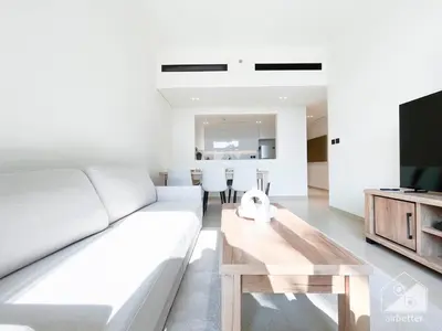 a living room with a white couch and a wooden table at Elegant 2 Bedroom Apartment -Binghatti Emerald JVC in Dubai