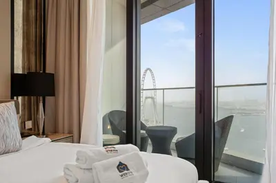 a hotel room with a view of the london eye at Werova - Sea View 3BR with Hotel Facilities Access in Dubai