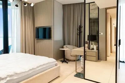 a bedroom with a bed and a desk and a computer at Werova - Sea View 3BR with Hotel Facilities Access in Dubai