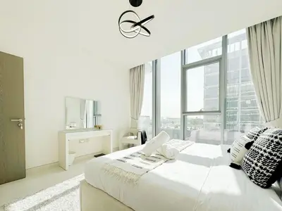 a white bedroom with a large bed and a window at Azure - 1-Bed Luxury by Crystal Lagoon, Downtown in Dubai