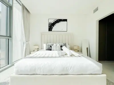 a white bedroom with a large bed with white sheets at Azure - 1-Bed Luxury by Crystal Lagoon, Downtown in Dubai