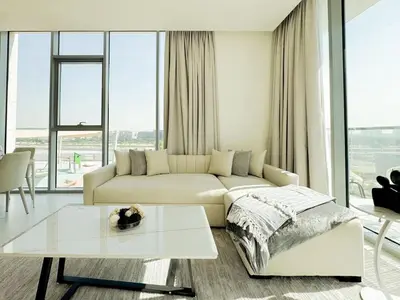 a living room with a white couch and a table at Azure - 1-Bed Luxury by Crystal Lagoon, Downtown in Dubai