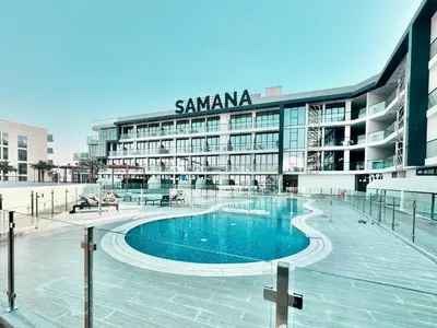 a large building with a swimming pool in front of it at Great deal Magnificent Brand New with Private PooL in Dubai