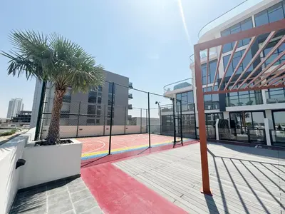 a tennis court with two palm trees in front of a building at Great deal Magnificent Brand New with Private PooL in Dubai