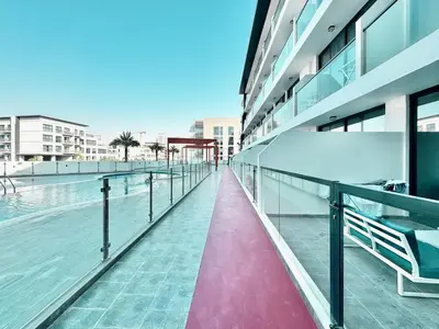 a building with a walkway next to a pool at Great deal Magnificent Brand New with Private PooL in Dubai