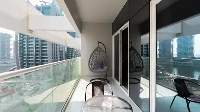 a balcony with chairs and a table on a building at Keyrock Living - Luxury 1BR with Lake View at Reva in Dubai