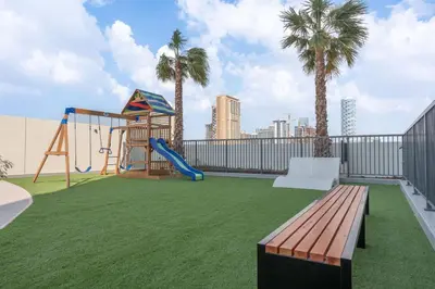 a playground with a slide and a swing at StayShort - Sleek Studio in Jumeirah Village Triangle in Dubai