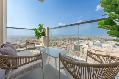 a balcony with chairs and a table and a view at StayShort - Sleek Studio in Jumeirah Village Triangle in Dubai