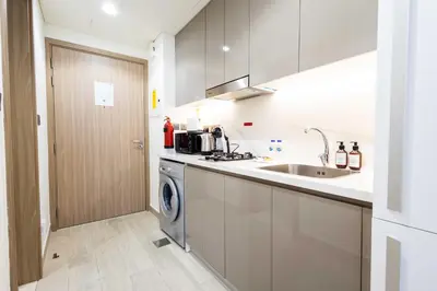 a kitchen with a sink and a washing machine at 10 Mins from Downtown Pool Gym Large Terrace in Dubai