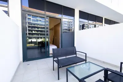 a balcony with a chair and a glass table at 10 Mins from Downtown Pool Gym Large Terrace in Dubai