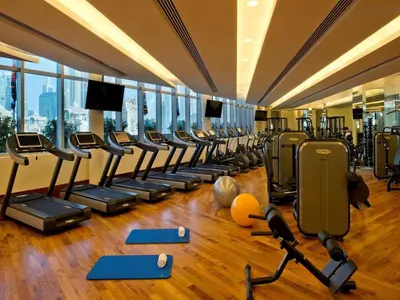 a gym with rows of treadmills and exercise equipment at Creston Suites The Dubai Mall Residences in Dubai