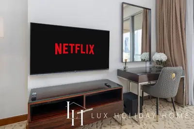 a living room with a television on a wall at LUX The EMAAR Fashion Avenue Studio 2 in Dubai