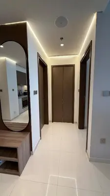 a hallway with a large mirror and a white tile floor at Seaside Elegance 1BR at Emaar Beachfront in Dubai