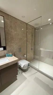 a bathroom with a shower and a toilet and a sink at Seaside Elegance 1BR at Emaar Beachfront in Dubai