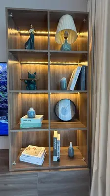 a wooden book shelf with a lamp and books at Seaside Elegance 1BR at Emaar Beachfront in Dubai