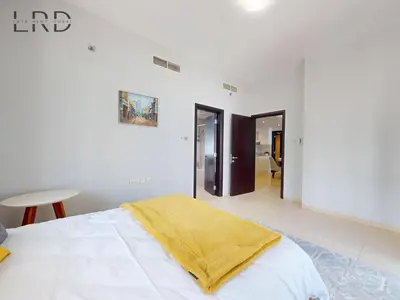 a white bedroom with a bed with a yellow blanket on it at Stylish 2BR Apartment Steps from Metro and Marina Mall in Dubai
