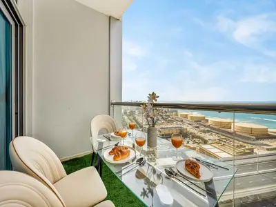 a dining room with a view of the ocean at Luxurious 2BR Stay Marina View in Dubai