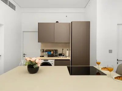 a kitchen with a refrigerator and a vase of flowers on a counter at Luxurious 2BR Stay Marina View in Dubai