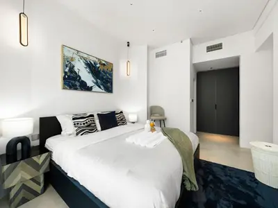 a bedroom with a large bed with white sheets at Luxurious 2BR Stay Marina View in Dubai