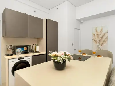 a kitchen with a table with a vase of flowers on it at Luxurious 2BR Stay Marina View in Dubai