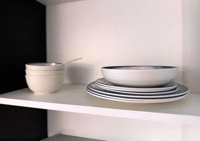 two bowls and plates sitting on a shelf at Capital Bay Tower B Comfort Studio in Dubai