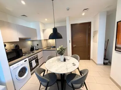a kitchen with a table and chairs in a kitchen at Great Location Near City Modern Sleeps 4 Guests in Dubai