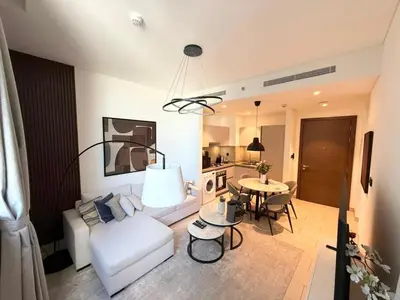a living room with a white couch and a table at Great Location Near City Modern Sleeps 4 Guests in Dubai