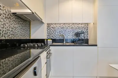 a kitchen with white cabinets and a sink at Luxury Sea View High Floor 3Bhk in Dubai