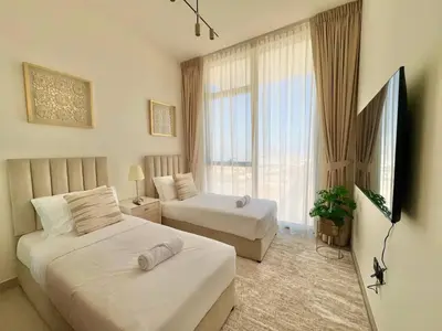 a hotel room with two beds and a window at Elegant 2br Jvc Private Pool, Balcony & Parking in Dubai