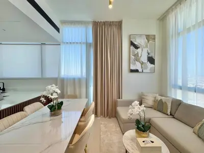 a living room with a couch and a table at Elegant 2br Jvc Private Pool, Balcony & Parking in Dubai