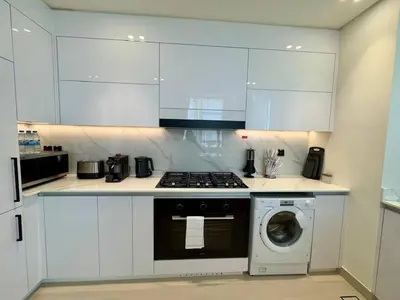 a kitchen with a stove and a washing machine at Elegant 2br Jvc Private Pool, Balcony & Parking in Dubai