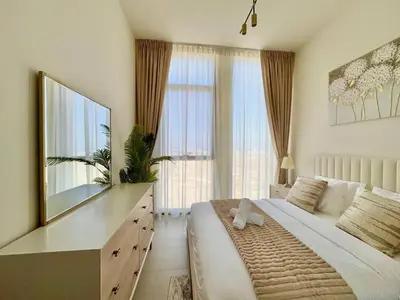 a bedroom with a large bed and a dresser with a mirror at Elegant 2br Jvc Private Pool, Balcony & Parking in Dubai