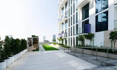 a walkway leading to a building with plants at Elegant 2br Jvc Private Pool, Balcony & Parking in Dubai