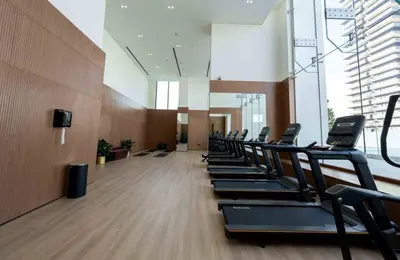 a row of treadmills in a gym with a row at Elegant 2br Jvc Private Pool, Balcony & Parking in Dubai
