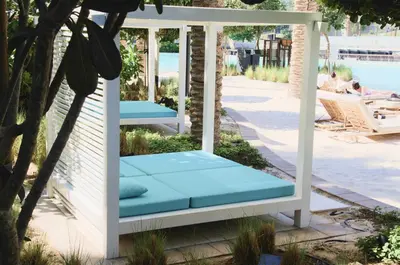 a porch swing with blue cushions on a patio at Knokey Dubai Creek Beach with Lagoon Pool access in Dubai