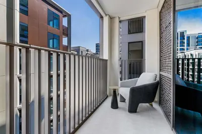 a balcony with a chair and a view of a city at Knokey Dubai Creek Beach with Lagoon Pool access in Dubai