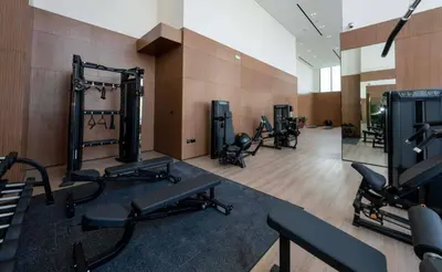 a gym with a row of exercise equipment in a room at Modern 1br In Jvc Balcony, Pool & Parking in Dubai