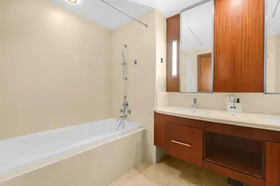a bathroom with a tub and a sink and a mirror at FIRST CLASS 2BR Spectacular Fountain Views in Dubai
