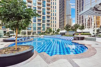 a large swimming pool in a city with tall buildings at FIRST CLASS 2BR Spectacular Fountain Views in Dubai