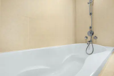a white bath tub with a shower in a bathroom at FIRST CLASS 2BR Spectacular Fountain Views in Dubai