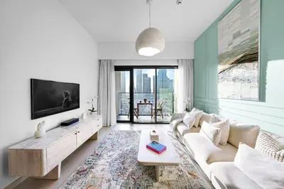 a living room with a couch and a tv at Burj Royale Lux 2-bedroom apartment with the best Burj Khalifa view in Dubai