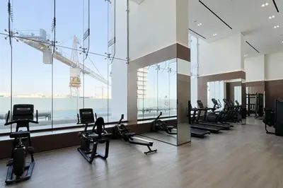 a gym with a lot of exercise equipment in a building at Large New Apartment Pool in JVC Community in Dubai