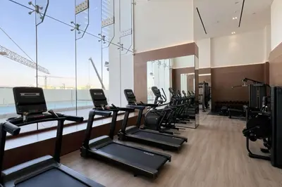 a gym with a row of treadmills at Large New Apartment Pool in JVC Community in Dubai