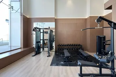 a gym with several tread machines in a room at Large New Apartment Pool in JVC Community in Dubai