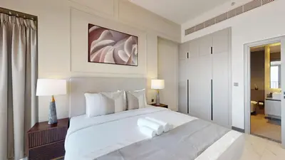 a bedroom with a large white bed and a bathroom at Mag Eye 910 - Magnificent One Bedroom in Meydan in Dubai