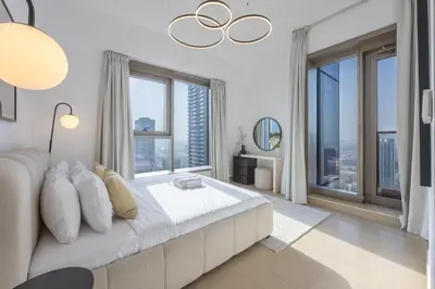 a bedroom with a large white bed with large windows at Vacationer I Luxury 2BR I Marina Views I Close to JBR Beach I Sparkle Tower in Dubai
